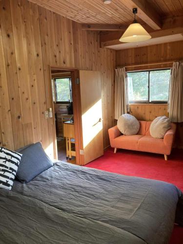 a bedroom with a bed and a couch in a room at Forest View Guesthouse in Omachi