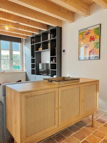 a living room with a wooden cabinet in a room at La Cachette Vigneronne in Givry