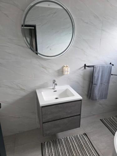 un bagno bianco con lavandino e specchio di Bill's villa a Lothlekane