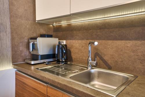 een keuken met een spoelbak en een koffiezetapparaat bij TATRA SUITES Luxury Studio A305 in Stary Smokovec