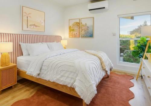 a bedroom with a bed and a window at Glenelg Beach House With Private Beachfront Pool in Glenelg