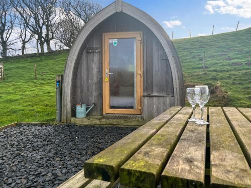 a wooden picnic table with a wine glass on it at Birds - Uk48489 in Dalton in Furness