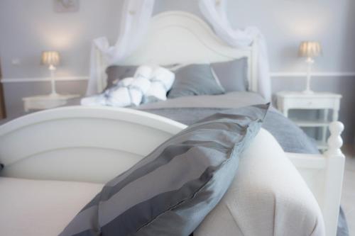 a white bed with a white headboard and pillows at B&B Donna Ada in Salerno