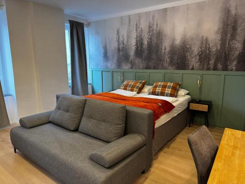 ein Schlafzimmer mit einem Bett und einer Couch in der Unterkunft Hirschenhof Apartments in Spital am Semmering