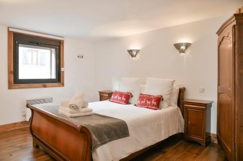 ein Schlafzimmer mit einem Bett mit roten Kissen und einem Fenster in der Unterkunft Le Chat De Lamartine - Clim Parking in Saint-Pierre-dʼAlbigny