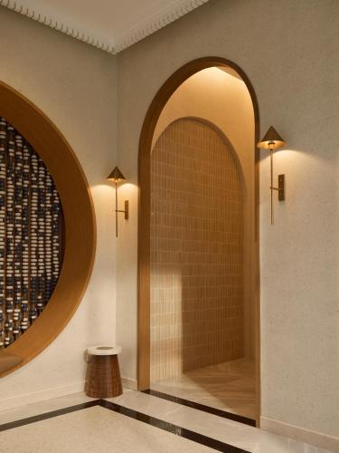 a hallway with two arches and a wall with two lights at Arco Phuket Town in Phuket
