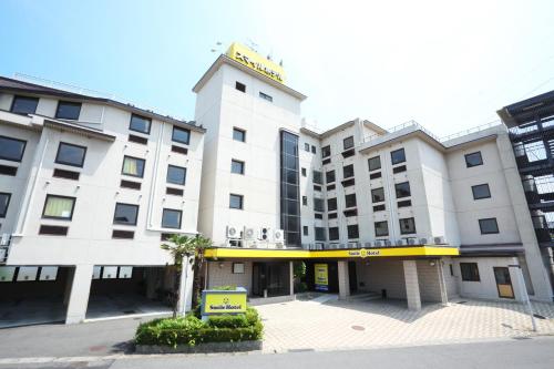 a white building with a sign on top of it at Smile Hotel Koriyama in Koriyama