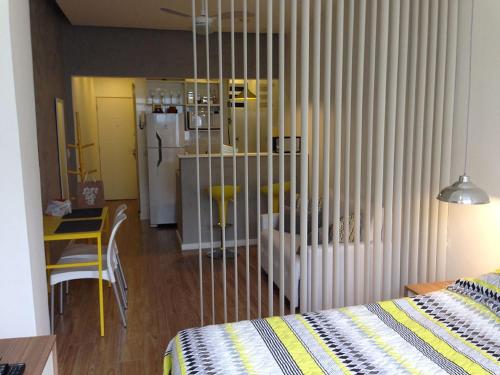 a bedroom with a bed and a table and a refrigerator at Studio Posto 6. in Rio de Janeiro