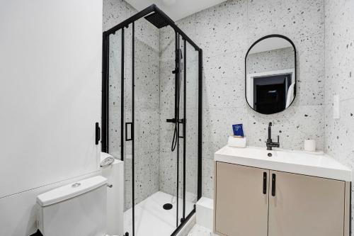 een badkamer met douche, wastafel en spiegel bij Comfortable and modern 2P studio - 16th Paris in Parijs