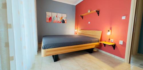 un piccolo letto in una camera con pareti rosse di Surrounded View Family - with Private Parking a Kavala