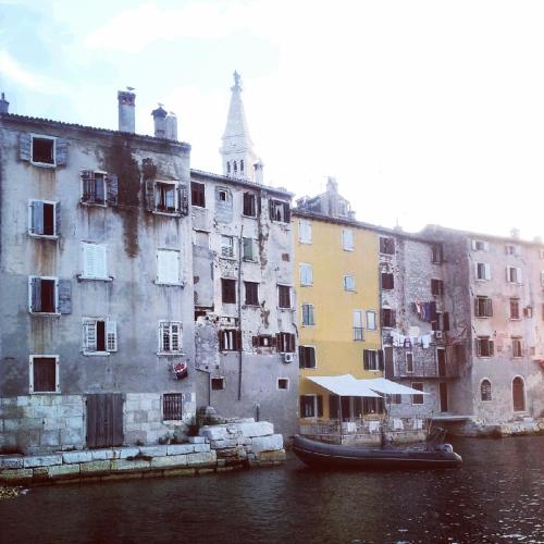 a boat in the water next to some buildings at Villa Segalla in Rovinj