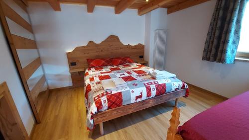 una camera da letto con un letto con una trapunta sopra di CAV MES VALLEES La Thuile a La Thuile