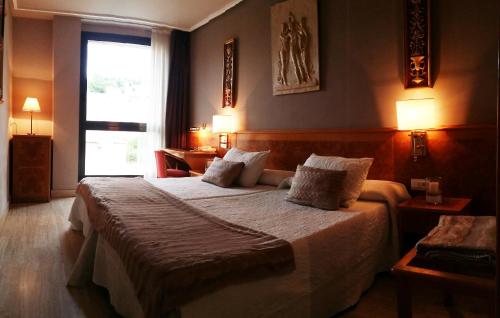 ein Schlafzimmer mit einem großen Bett und zwei Kissen in der Unterkunft Hotel San Polo in Salamanca