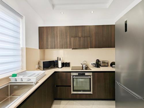 a kitchen with wooden cabinets and a sink at Valley View 4 in Luqa