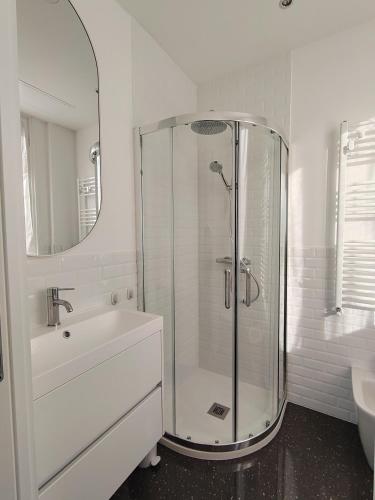 a white bathroom with a shower and a sink at La Terrazza di Chiavari in Chiavari