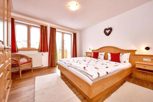 a bedroom with a large bed with red pillows at Landhaus Bergliebe in Mittenwald