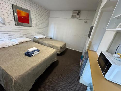 Zimmer mit 2 Betten und einem TV. in der Unterkunft Mayfield Motel in Mayfield