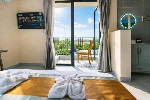 Schlafzimmer mit einem Bett und Blick auf einen Balkon in der Unterkunft Như Ý Hotel Tây Ninh in Tây Ninh