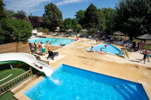 a group of people in the swimming pools at a resort at ZEcamping 3 étoiles familial do friendly piscine chauffée restaurant et bar in Les Eyzies-de-Tayac