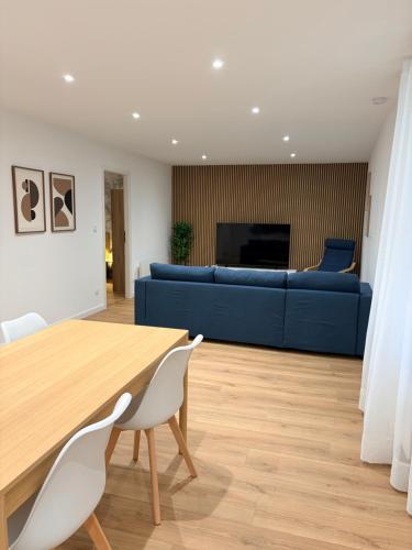een woonkamer met een tafel en een blauwe bank bij L élégance centre historique Dole 70 m2 in Dole