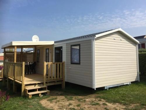 a mobile home with a porch and a deck at ZEcamping 4 avec pet friendly piscine couverte à 200m de la plage in Plomodiern