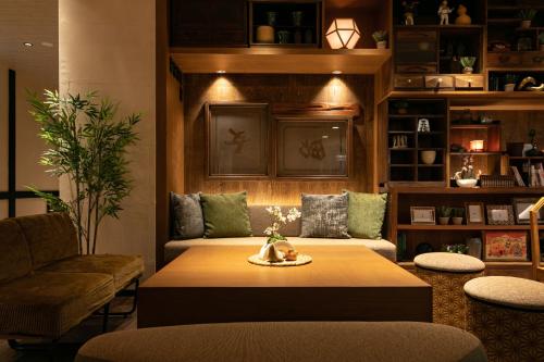 a living room with a table and a couch at Onsen Guest House Tsutaya in Hakone
