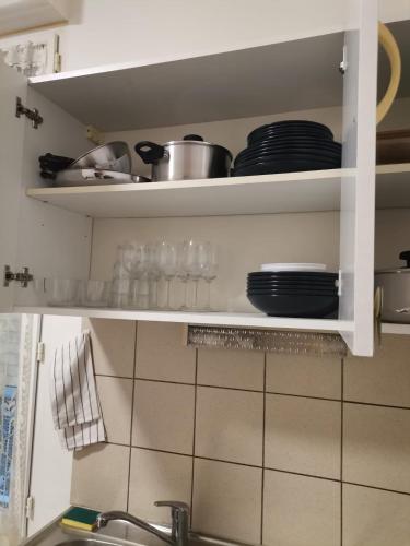une étagère de cuisine avec des assiettes et des plats dessus dans l'établissement Studio mignon en plein centre de Vichy, à La Celle-sous-Gouzon