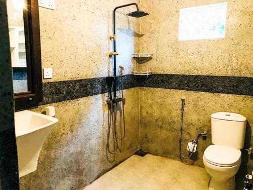 a bathroom with a shower and a toilet and a sink at Villa Arcadia in Tangalle
