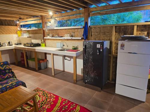 a kitchen with a sink and a refrigerator at J home stay in Maluk