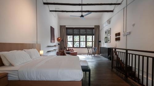 a bedroom with a large bed and a living room at Heritage Villa by Aayu - 10 mins walk to Armenian St in George Town