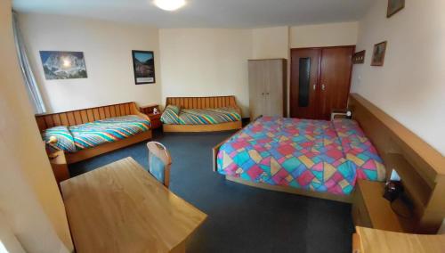 a small room with two beds and a couch at Appartamento IN CENTRO a Predazzo in Predazzo