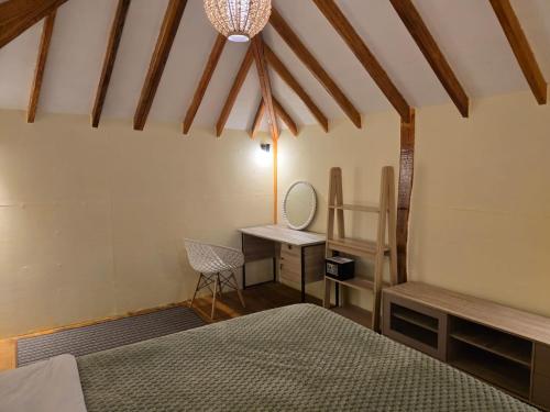 a bedroom with two beds and a table and a desk at J home stay in Maluk