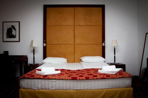 a bedroom with a large bed with towels on it at Visconti Militari in Bucharest