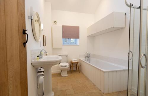 e bagno con lavandino, servizi igienici e vasca. di Kerry House a Deddington
