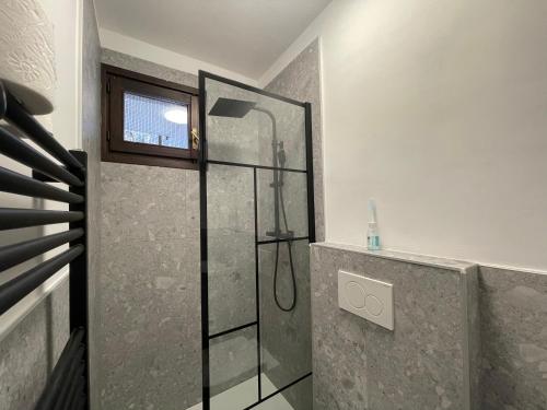 een douche met een glazen deur in een badkamer bij La Casa di Paolo - Monolocale ristrutturato con vista sulle montagne in Caspoggio