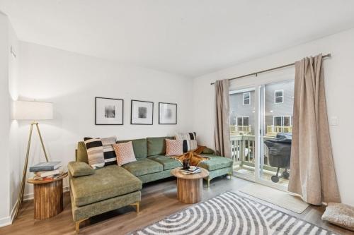 een woonkamer met een groene bank en een raam bij The Wonder 