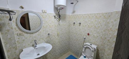 een badkamer met een wastafel en een spiegel en een toilet bij Temesegen Hotel in Āksum