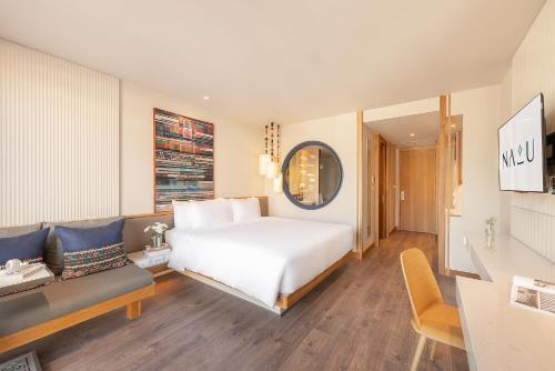 a bedroom with a bed and a living room with a couch at Na U Hotel in Chiang Mai
