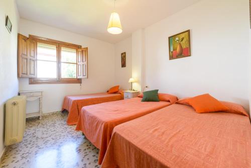two beds in a room with orange sheets at Alojamiento Rural La Era in Cónchar