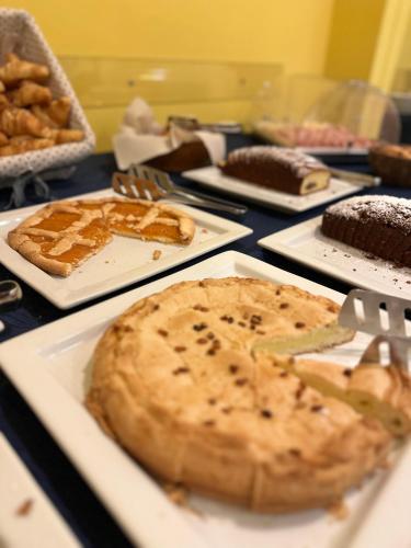 ein Tisch mit verschiedenen Arten von Kuchen und Torten in der Unterkunft Hotel Mediterraneo in Chianciano Terme