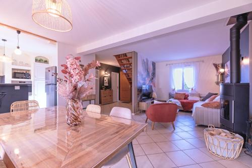 eine Küche und ein Wohnzimmer mit einer Vase aus Blumen auf dem Tisch in der Unterkunft Villa Les Figuiers in Tallard