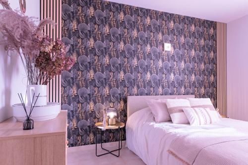 ein Schlafzimmer mit einem Bett und einer Tapete mit Elefanten in der Unterkunft Villa Les Figuiers in Tallard