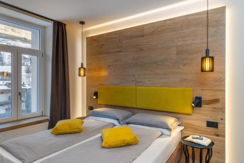 une chambre avec un grand lit avec des oreillers jaunes dans l'établissement Hotel Pejo, à Peio Fonti