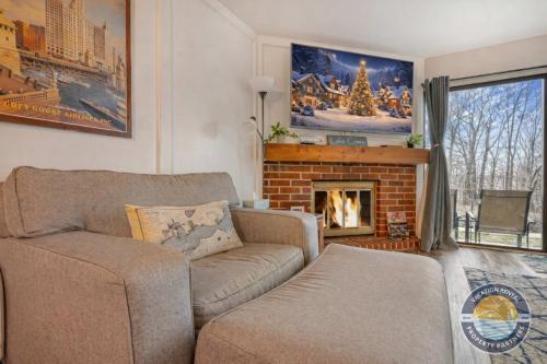 ein Wohnzimmer mit Sofa und Kamin in der Unterkunft Modern Lake Geneva Condo with Year-Round Views in Lake Geneva