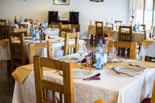 a dining room with tables with plates and wine glasses at Pensiunea Sureanu in Tău Bistra