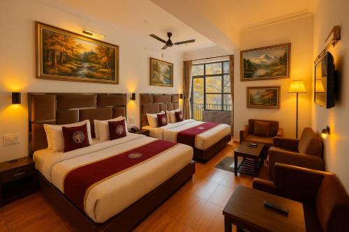 een hotelkamer met twee bedden en een bank bij Hotel The great #ambience #balcony view #mountainview #parking in Nainital