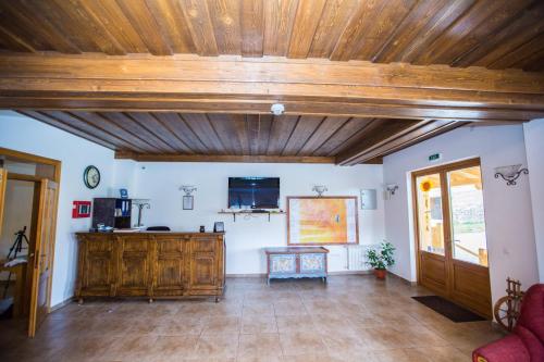 a living room with a wooden ceiling and a tv at Pensiunea Sureanu in Tău Bistra