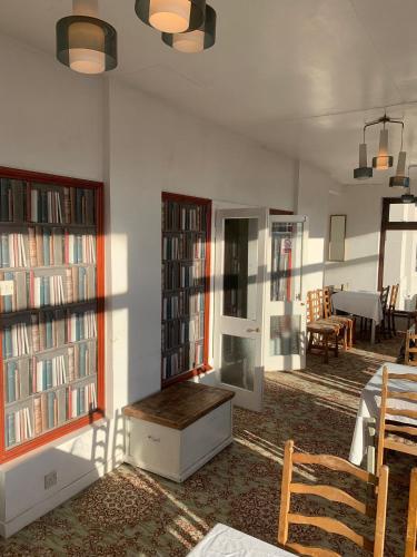 a room with several bookshelves and a table and a room with a table at Savoy Hotel in Weston-super-Mare