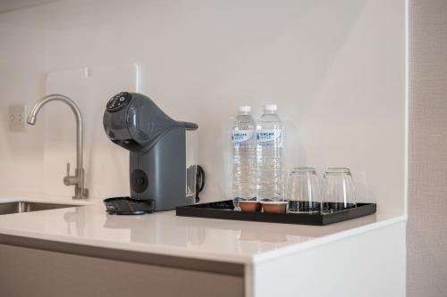 un bancone con bottiglie d'acqua e bicchieri di The Rich Grand Residence Sukhumvit a Bangkok