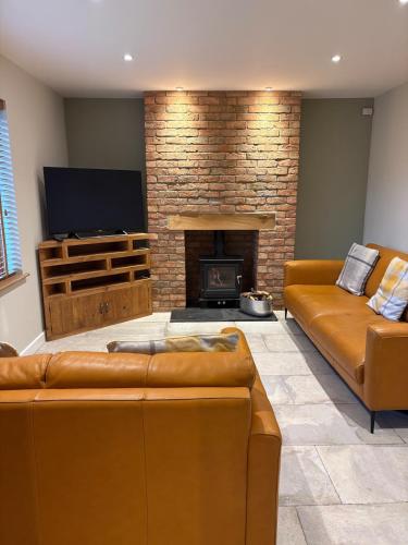 een woonkamer met een bank en een open haard bij The Old Pitman's house in Ollerton